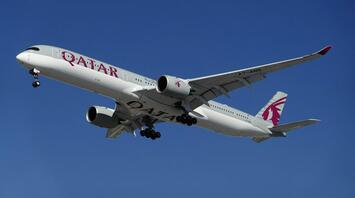 Qatar Airways aircraft in flight against clear sky