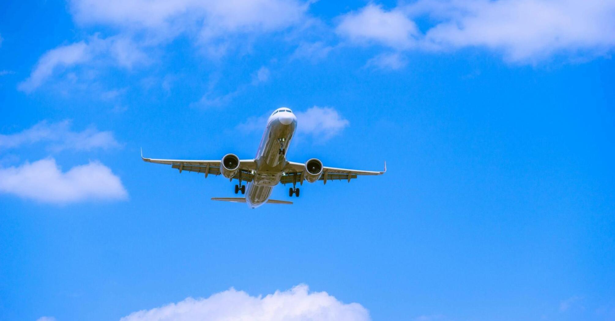 Airplane approaching for landing against blue sky