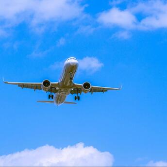 Airplane approaching for landing against blue sky