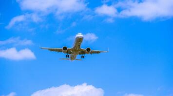 Airplane approaching for landing against blue sky