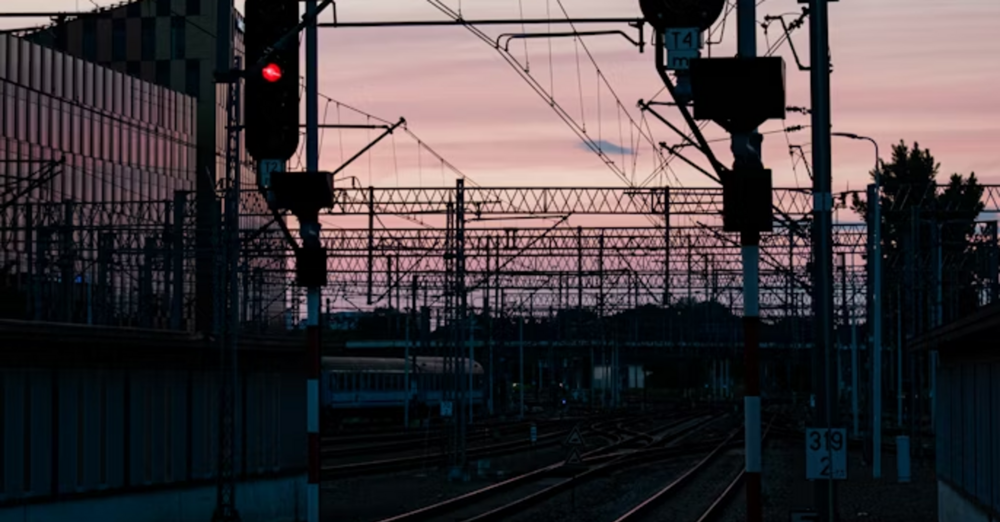 Railway signals glowing red at sunset