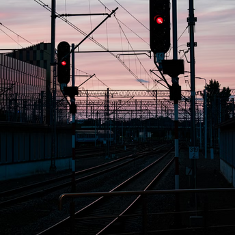 Railway signals glowing red at sunset
