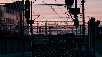 Railway signals glowing red at sunset