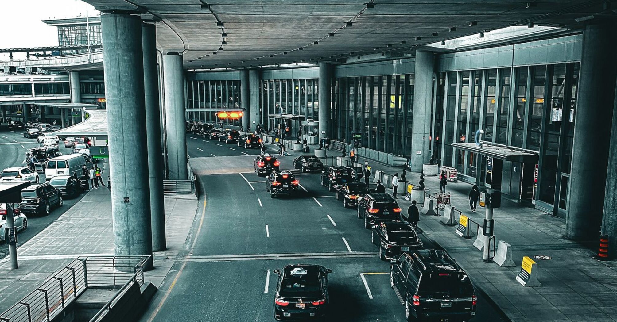 Cars lining up outside Berlin Brandenburg Airport terminal under a covered roadway
