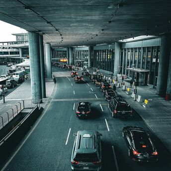 Cars lining up outside Berlin Brandenburg Airport terminal under a covered roadway
