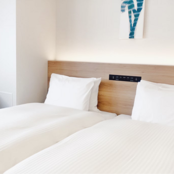 Modern hotel room with twin beds and minimal decor