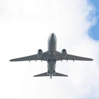 Airplane flying against cloudy sky