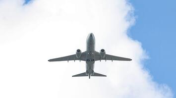Airplane flying against cloudy sky