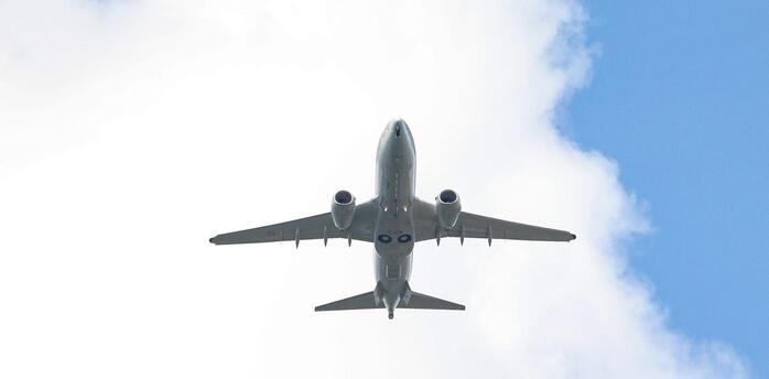 Airplane flying against cloudy sky