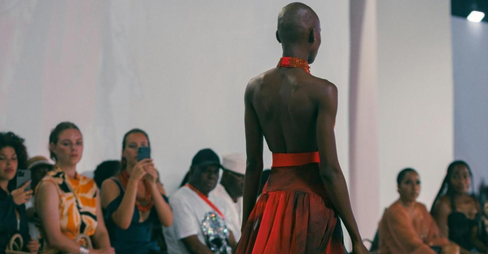 Model walking runway in flowing red gown