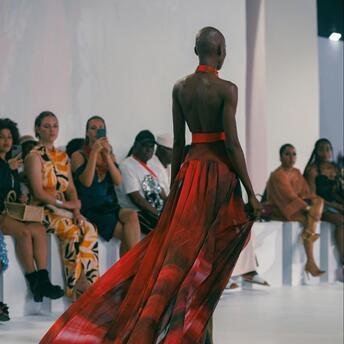 Model walking runway in flowing red gown