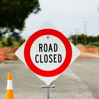 Road closed sign blocking empty street during construction