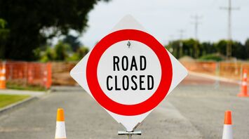Road closed sign blocking empty street during construction