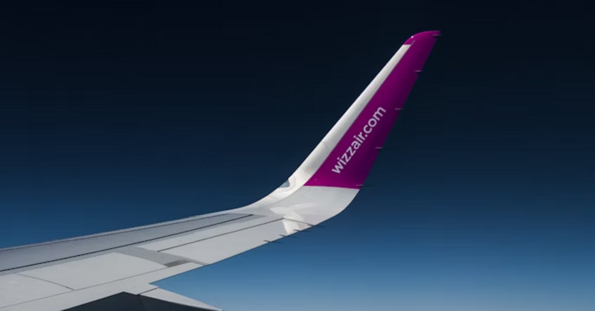 Wizz Air aircraft wing flying above clouds