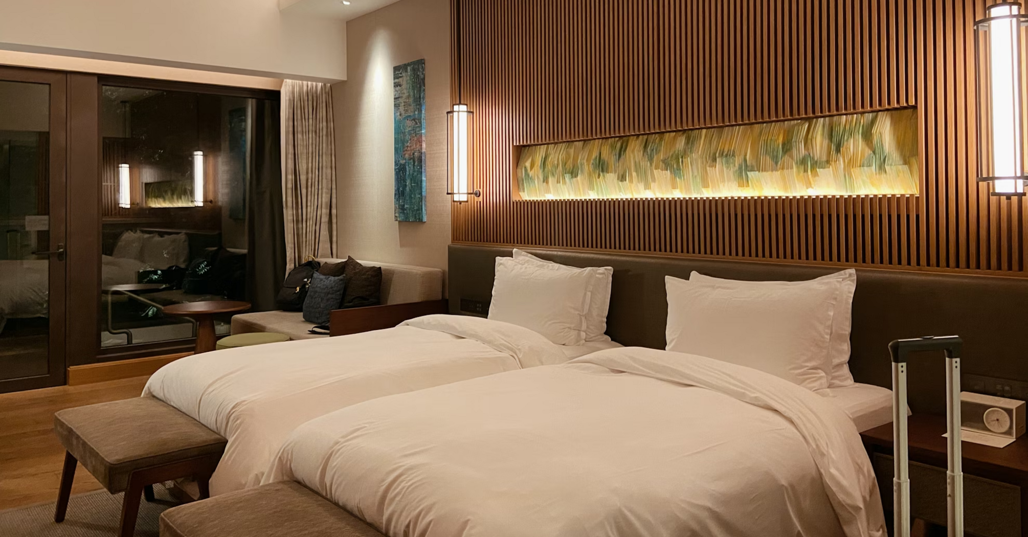 Modern hotel room with twin beds and warm lighting