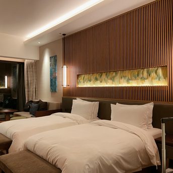 Modern hotel room with twin beds and warm lighting