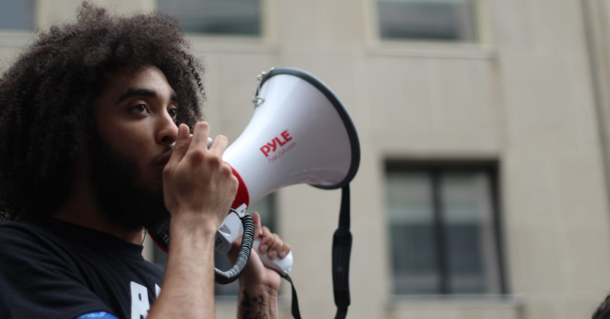 Person speaking through a megaphone during a public demonstration