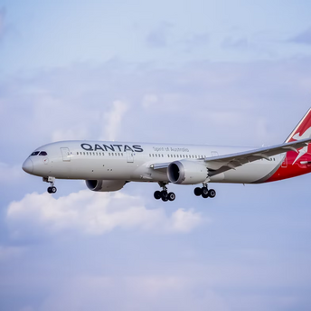 Qantas airplane in flight against a partly cloudy sky