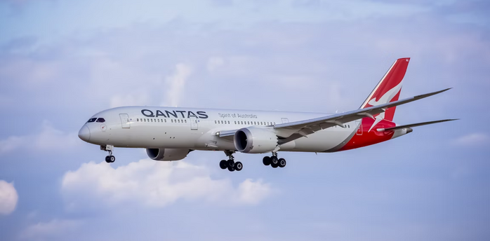 Qantas airplane in flight against a partly cloudy sky