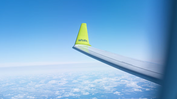 airBaltic airplane wing with logo in flight