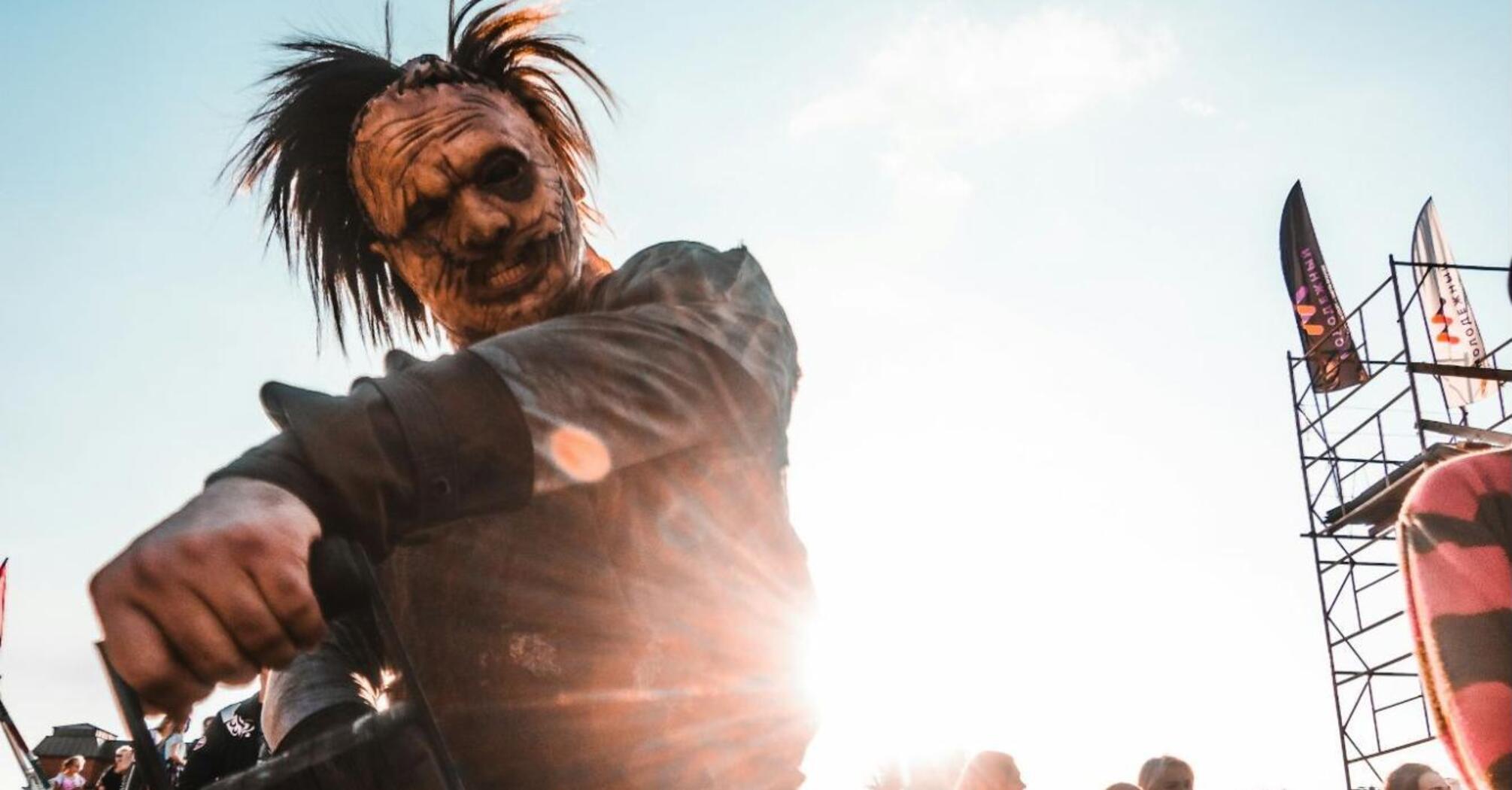 Performer in horror costume entertaining visitors at outdoor event