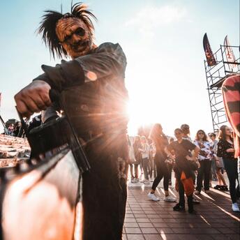Performer in horror costume entertaining visitors at outdoor event