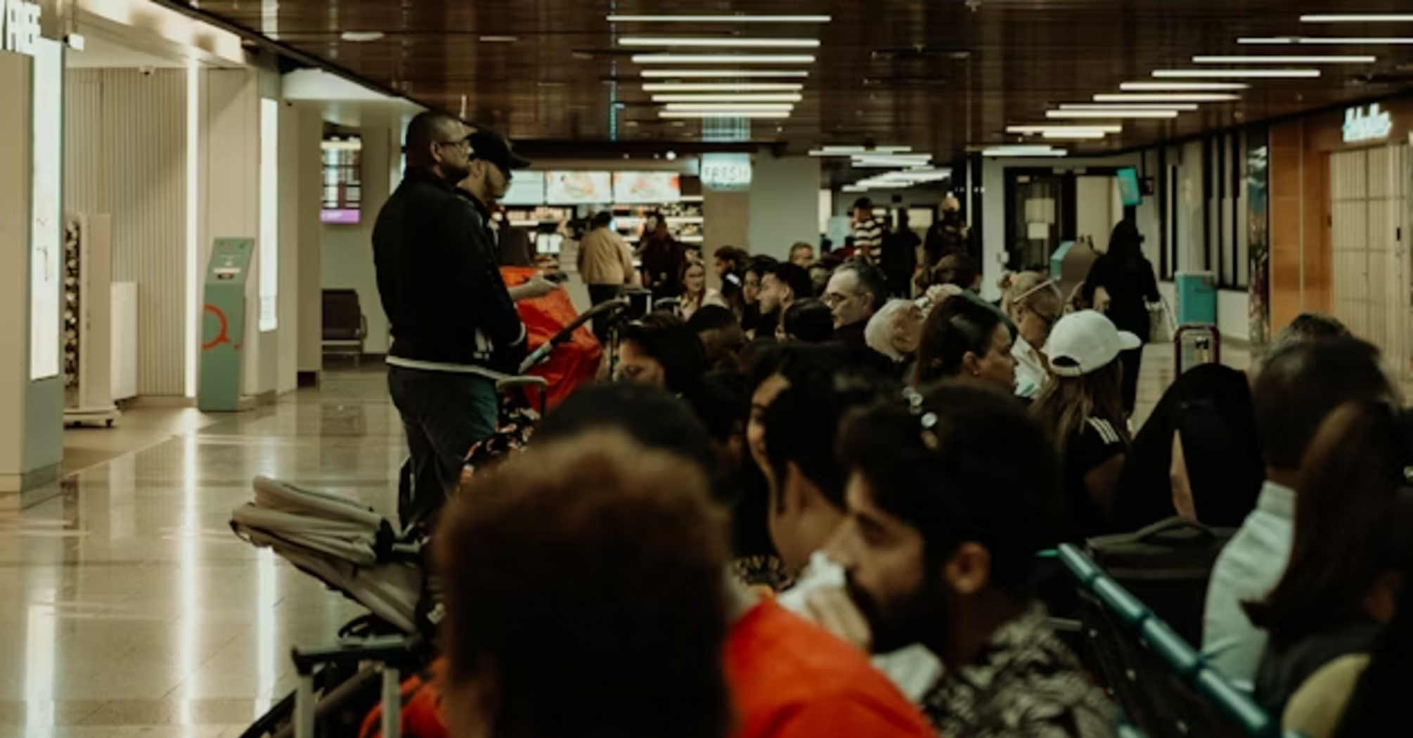 Passengers waiting in crowded airport seating area