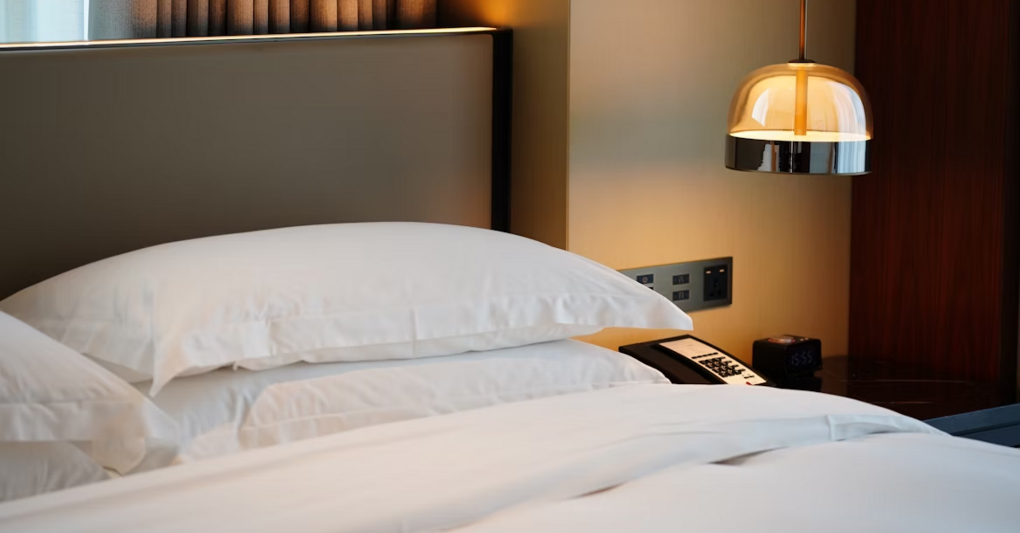 Modern hotel room with fresh white bedding and soft lighting