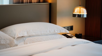 Modern hotel room with fresh white bedding and soft lighting