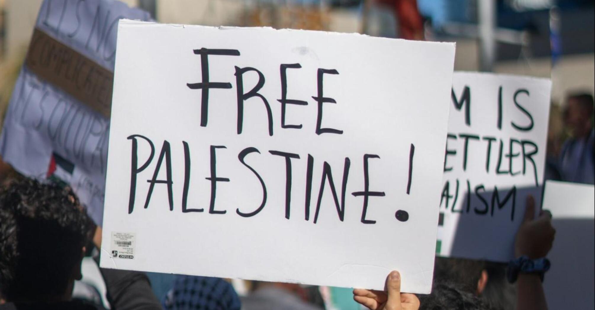 Protester holding a sign reading "Free Palestine"