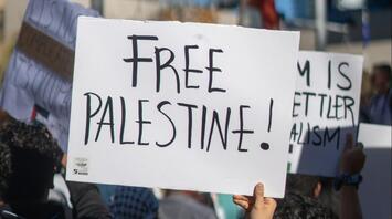 Protester holding a sign reading "Free Palestine"