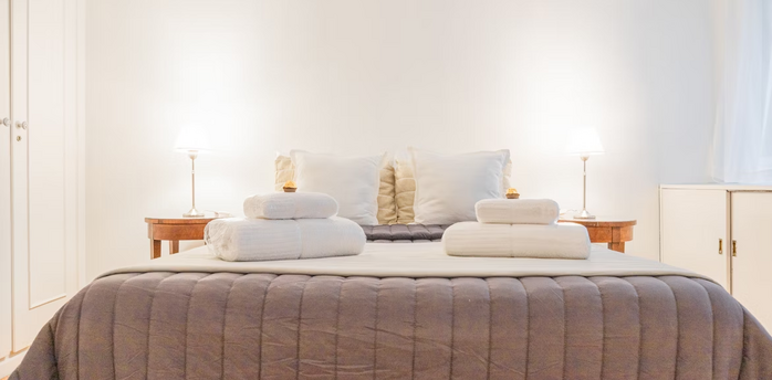 Modern hotel bedroom with fresh towels and soft lighting