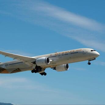Etihad Airways aircraft taking off against blue sky
