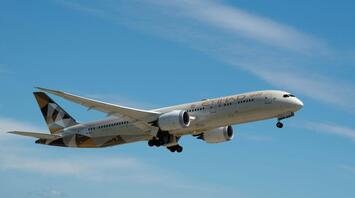 Etihad Airways aircraft taking off against blue sky