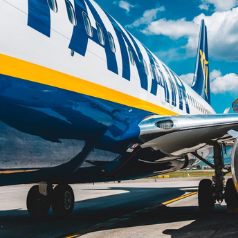 Close-up view of a Ryanair airplane on the runway under a blue sky