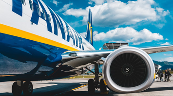 Close-up view of a Ryanair airplane on the runway under a blue sky