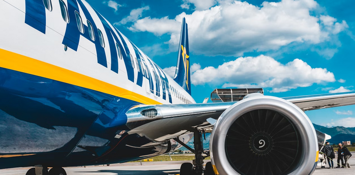 Close-up view of a Ryanair airplane on the runway under a blue sky