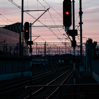 Railway tracks with red signal lights at sunset