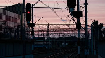 Railway tracks with red signal lights at sunset