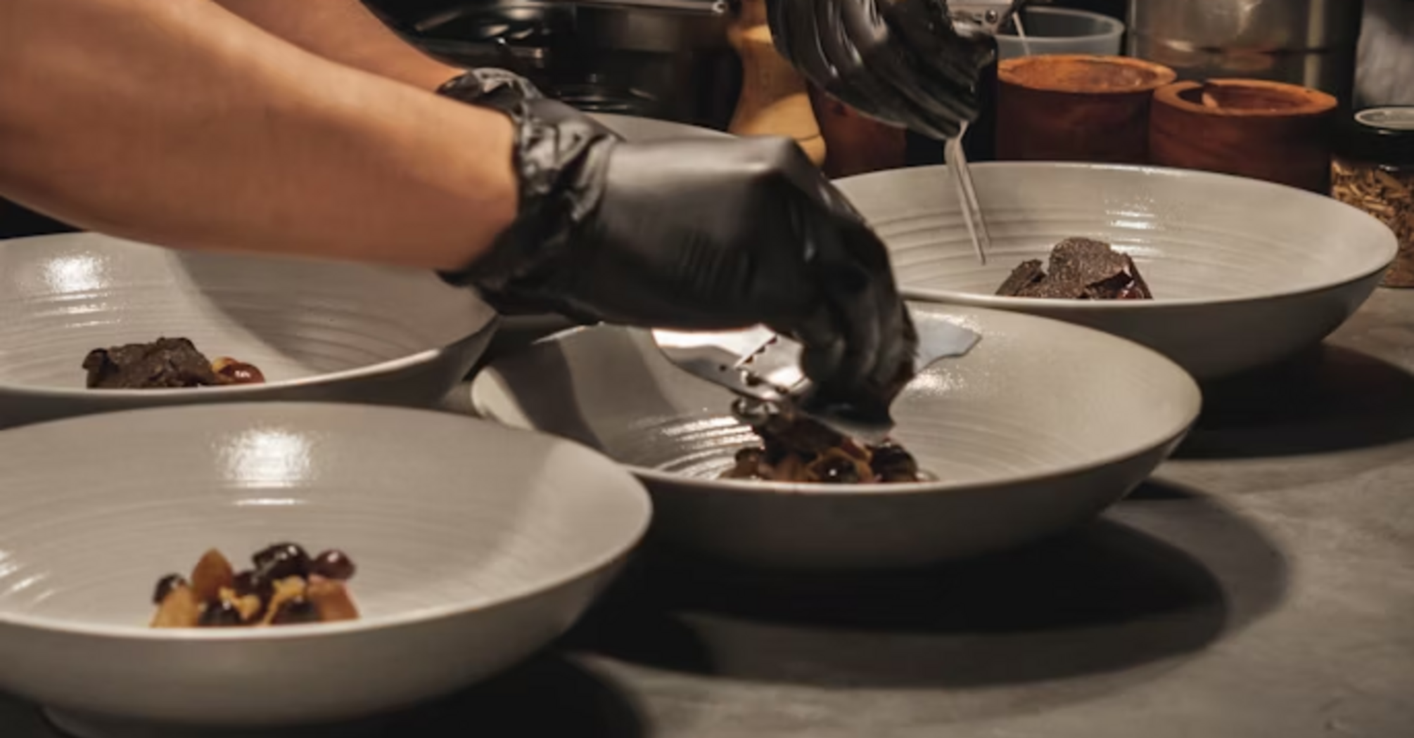 Chefs plating gourmet dishes in a restaurant kitchen