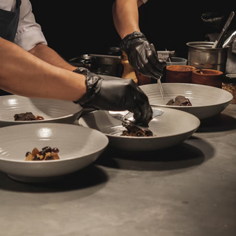 Chefs plating gourmet dishes in a restaurant kitchen