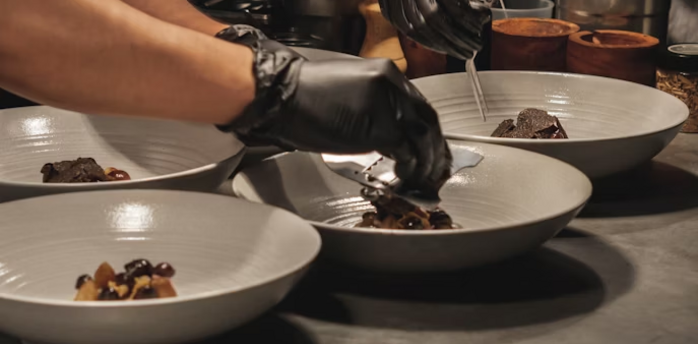 Chefs plating gourmet dishes in a restaurant kitchen