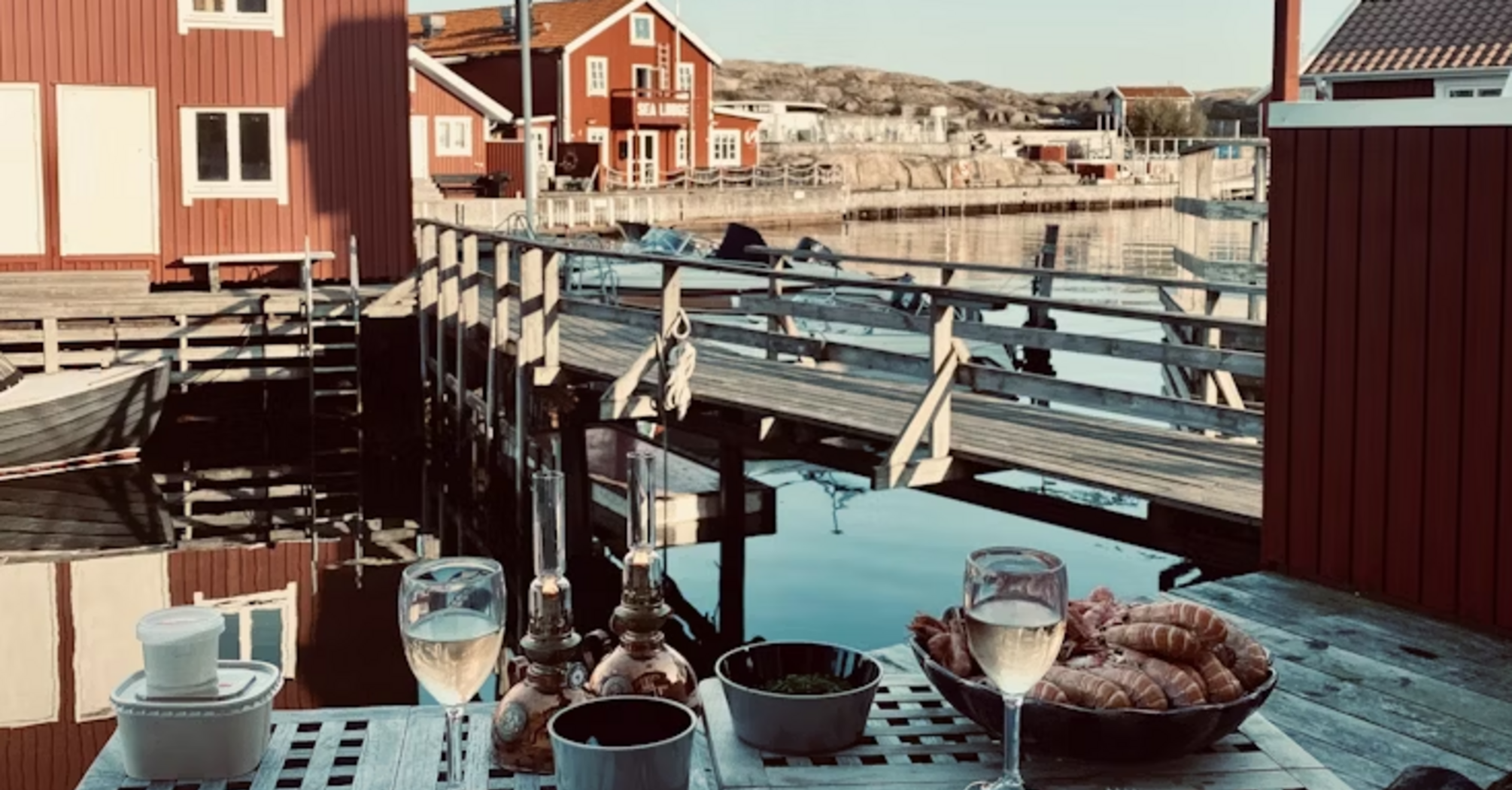Waterfront dining setup with Swedish red cottages