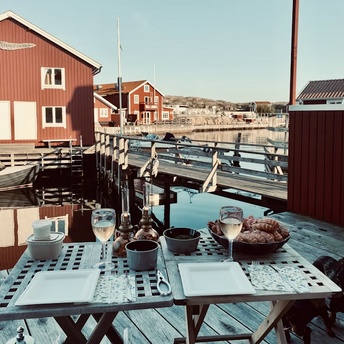 Waterfront dining setup with Swedish red cottages