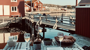 Waterfront dining setup with Swedish red cottages