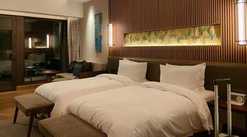 Modern twin hotel room with warm lighting