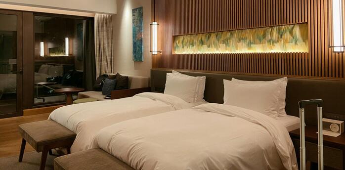 Modern twin hotel room with warm lighting