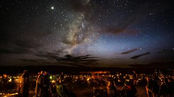 People stargazing under the Milky Way at night