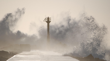 Storm waves crashing over coastal pier during Typhoon Tapah