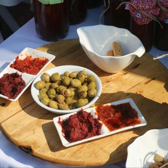 A serving board with olives and red olive pastes